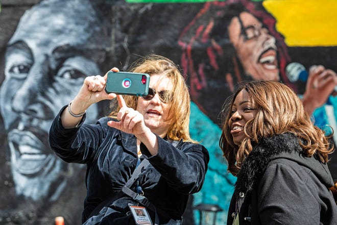 Community members take selfies in front of the Bob Marley mural, in front of One Love Park/Tatnall Street Park in Wilmington, Wednesday, March 20, 2024. Marley, who was born in Wilmington and lived in the family home in 24th Street, Mayor Purzycki gave him the key to the city.