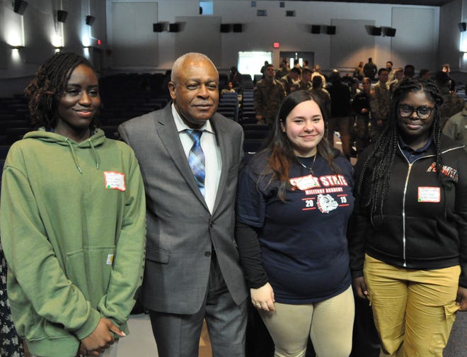Col. George London, one of the Air Force's first Black test pilots, greets students from First State Military Academy at the Tuskegee Airmen Commemoration Day in Dover March 28. From left, Amani Mays-Winter, Col. London, Shiane Polk-Johnson and Re’myah Wallace.