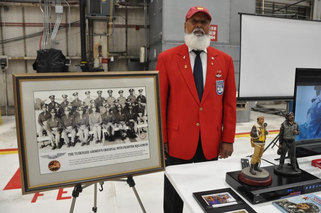 Standing next to a photo of the original 99th Fighter Squadron of the Tuskegee Airmen is David Terrell, from the Heart of Carolina Chapter of the Tuskegee Airmen in North Carolina. He's retired from the Air Force, a former loadmaster for the C-130 cargo plane.