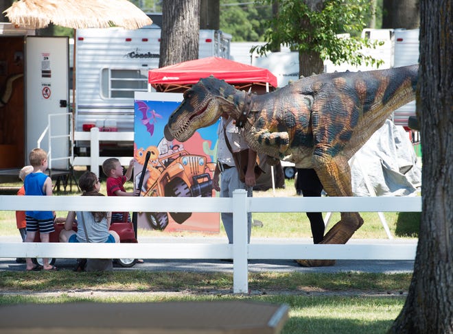 Children meet a dinosaur at the 99th annual Delaware State Fair in Harrington.