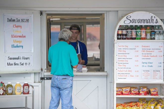 Austin Wyre takes a customer's order at Savannah's in the back parking lot of the Prices Corner Shopping Center.