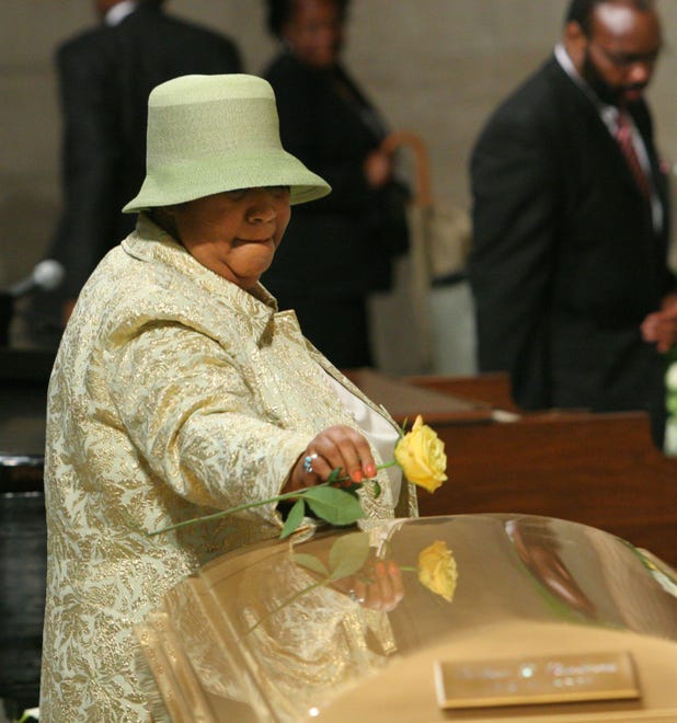 Aretha Franklin place a rose on the casket of Luther Vandross before she sings at his funeral, Friday July 8, 2005 in New York.