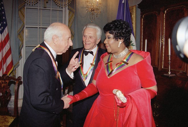 Singer Aretha Franklin listens to composer Morton Gould, as actor Kirk Douglas looks on following a dinner at the State Department in Washington  Saturday, Dec. 3, 1994. The dinner was held to honor them as recipients of the Kennedy Center Honors of 1994. Also honored were songwriter Pete Seeger and Director Harold Prince.