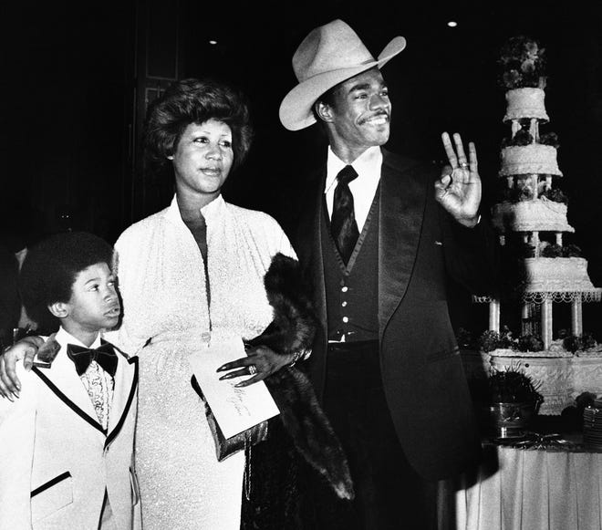 Aretha Franklin and her new husband, Glen Turman, arrive at a Los Angeles hotel, April 17, 1978 for their wedding reception. Turman signals his okay and pleasure at the reception as Kecalf (cq) 8, Aretha's son by a previous marriage looks on. The couple married recently,had planned a reception at her Beverly Hills home on Saturday but the party was rained out, and moved to the hotel for the Sunday party. (AP Photo/Doug Pizac)