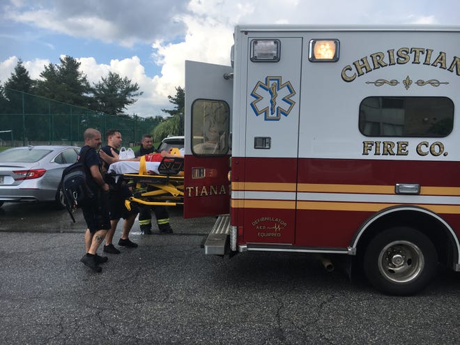 Paramedics load a lifeguard at the Cavalier Country Club Apartments into an ambulance after he reportedly was struck by lightning.