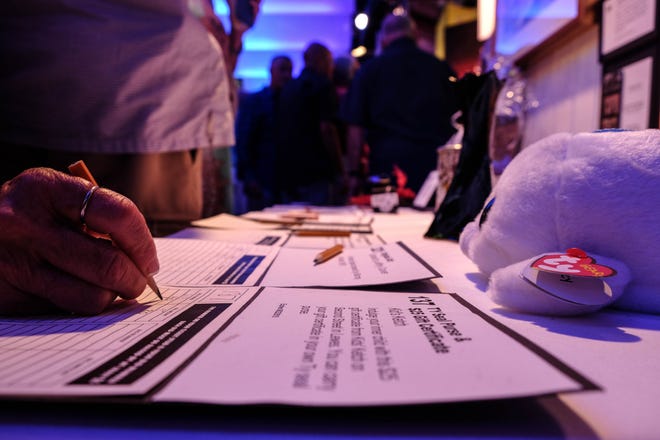 A woman places a offer during CAMP Rehoboth's silent auction on day one of Sundance, the nonprofit's 31st annual fundraiser that was held in memory co-founder Steve Elkins, who died earlier this year of lymphoma.