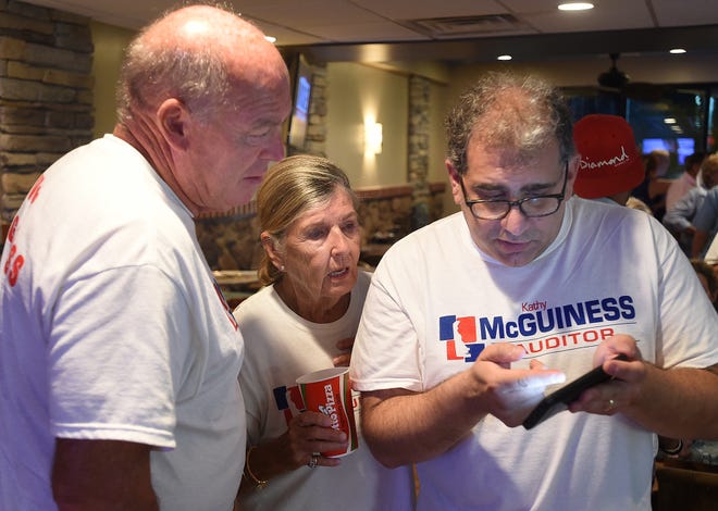 From left, House Speaker Pete Schwartzkopf, Angie (Kathy McGuiness' mother) and Spiros Mantzavinos check for primary results at Grotto's Pizza in downtown Rehoboth Beach.