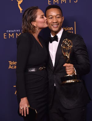 Chrissy Teigen lays a congratulatory smooch on husband John Legend after he won his first Emmy Sunday, joining the EGOT club.