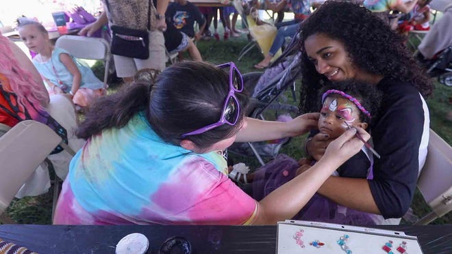 A young guest gets a colorful new look at the Faerie Festival Sunday, Sept. 16, 2018, at Rockwood Park in Wilmington.