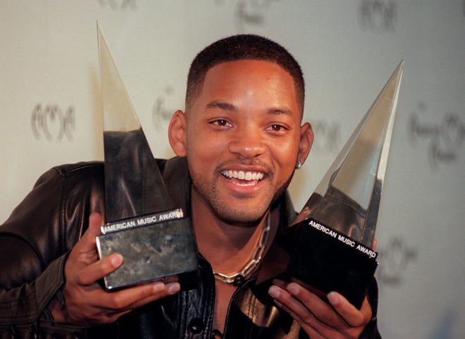 Will Smith holds up two of the three awards he won at the American Music Awards at the Shrine Auditorium in Los Angeles on Jan. 11, 1999. Smith won awards for pop rock favorite album, soul, rhythm and blues favorite album, and favorite male artist.
