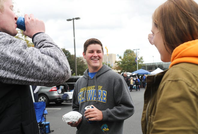 University of Delaware student Mike Rutecki of Springifield Pa. (center) hangs out in the tailgate with cousin Dan Rutecki of Broomall, Pa., and Kayla Feairheller of West Chester, Pa. before Delaware took on Elon at Delaware Stadium Saturday.