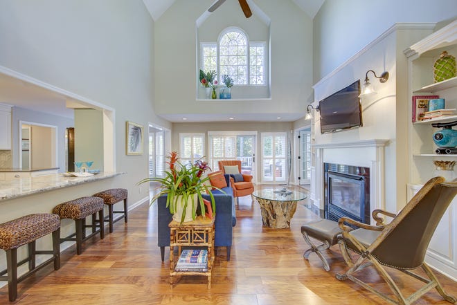 The gathering room at 204 Lakeview Shores is two stories tall and adjoins the kitchen and a screened porch.