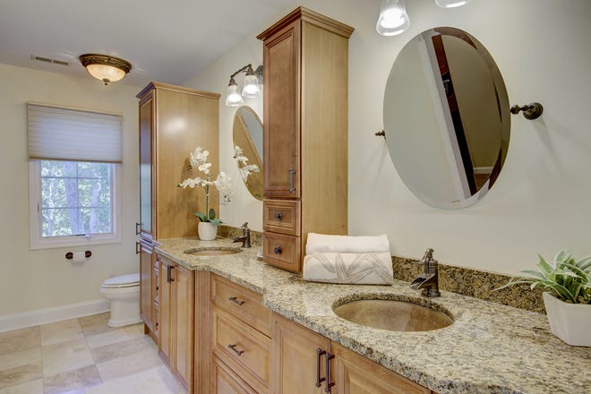 This bath at 204 Lakeview Shores  features dual vanities and wood cabinetry.