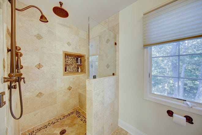 This bath at 204 Lakeview Shores in Rehoboth Beach has a rain head and custom tile work.