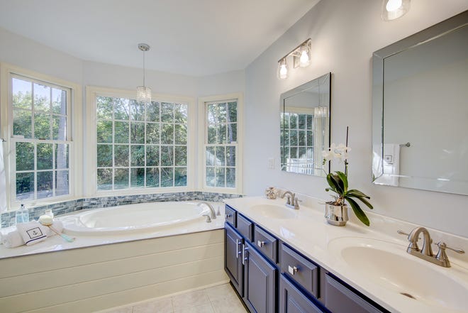 The master bath at 204 Lakeview Shores in Rehoboth Beach features dual vanities and a whirlpool tub.