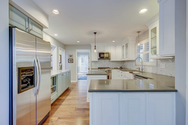 The chef's kitchen at 204 Lakeview Shores has white custom cabinets and quartz countertops.