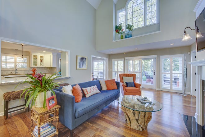 The gathering room at 204 Lakeview Shores is two stories tall and adjoins the kitchen and a screened porch.