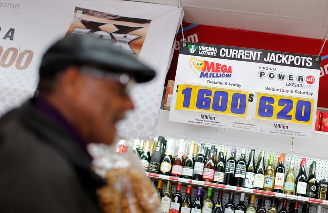 A sign shows the current Mega Millions and Powerball lottery jackpots as a customer purchases Mega Millions lottery tickets at a retailer in Arlington, Virginia Monday.