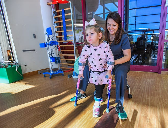 Physical therapist Chelsie Reed works with three-year-old Preslee Holcomb, who has a rare condition called AFM, Monday, October 22, 2018 at the Shriners Hospital for Children in Greenville.