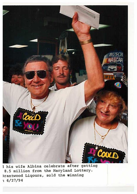 Dan Thoma and his wife Albina celebrate after getting the first installment of their $8.5 million from the Maryland Lottery in 1994. Harvey Jacobs, left, owner of Brantwood Liquors, sold the winning ticket.