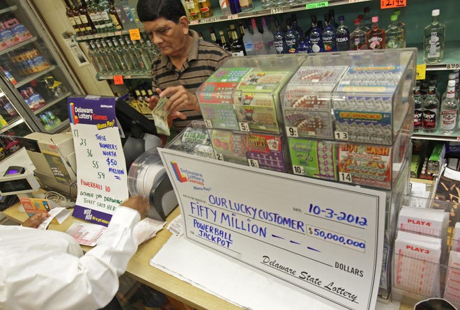 Navin Patel, co-owner of Cutrona'a Liquors on N. Market Street helps a customer purchase lottery tickets on Thursday, October 4, 2012. Wednesday night $50 million dollar lottery ticket was sold at the store.