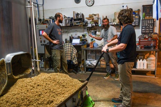 Adam Davis, Bryan Brushmiller and Andrew Lovelass chat while working on a new batch of Lost IPA at the Burley Oak Brewery in Berlin on Wednesday, Oct 24, 2018.
