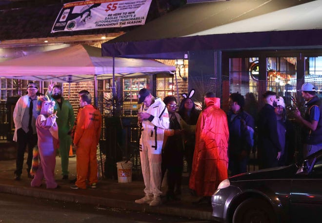 Halloween Loop participants linger outside Catherine Rooney's as Wilmington police and other officers keep the peace after reports of gunfire and fighting at Kelly's Logan House in Trolley Square at the conclusion of the city's Halloween Loop early Sunday.