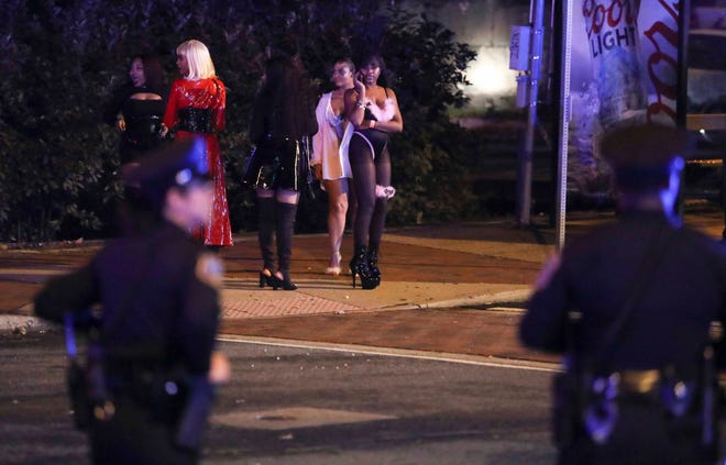 Wilmington police and other officers keep the peace after reports of gunfire and fighting at Kelly's Logan House in Trolley Square at the conclusion of the city's Halloween Loop early Sunday.