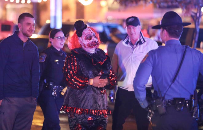 A costumed Wilmington Halloween Loop participant speaks to police after reports of gunfire and fighting at Kelly's Logan House in Trolley Square at the conclusion of the city's Halloween Loop early Sunday. There were no immediate reports of injuries.