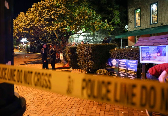 Wilmington police and other officers keep the peace after reports of gunfire and fighting at Kelly's Logan House in Trolley Square at the conclusion of the city's Halloween Loop early Sunday.