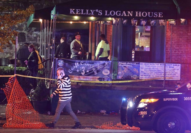 Workers begin the after-party cleanup as Wilmington police investigate a report of gunfire at Kelly's Logan House in Trolley Square at the conclusion of the city's Halloween Loop early Sunday.