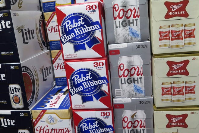 In this photo taken on Thursday, Nov. 8, 2018, cases of Pabst Blue Ribbon and Coors Light are stacked next to each other in a Milwaukee liquor store. Pabst Brewing Company and MillerCoors are heading to trial starting Monday, Nov. 12, to settle a contract dispute in which Pabst accuses the brewing giant of trying to undermine its competitor by breaking a contract to make their products. (AP Photo/Ivan Moreno) ORG XMIT: RPIM201