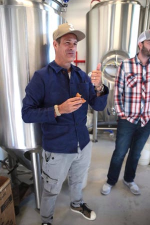 Dogfish Head founder Sam Calagione sneaks an apple cider doughnut from Fifer Orchards while making a new collaborative beer called Have Another Donut. It debuts at the brewery's Rehoboth Beach brewpub on Friday, Nov. 16 at 11 a.m. to help kick off the two-day Analog-A-Go-Go beer and music festival.
