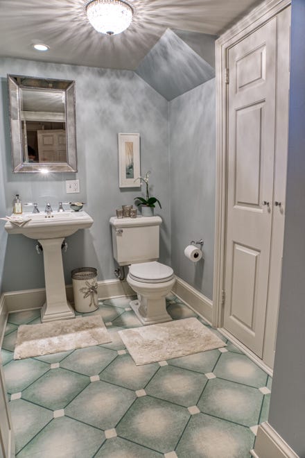 The wood floor in the powder room at 2 Alapocas Drive has been faux painted to mimic ceramic tile.