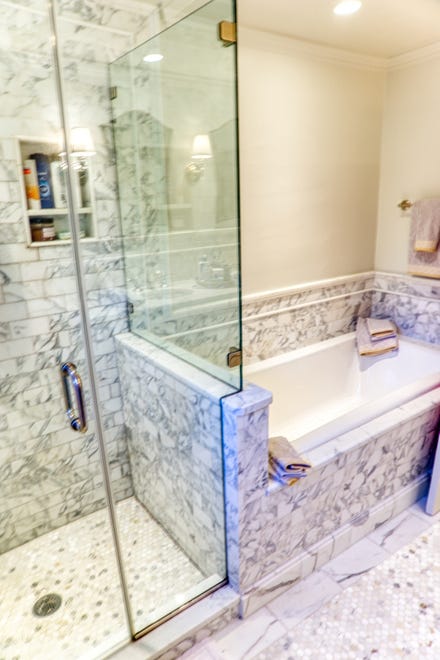 The master bath at 2 Alapocas Drive features a glassed-in shower and tiled tub.