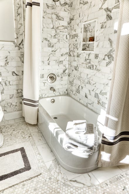 The tub in the hall bath at 2 Alapocas Drive features a soothing black and white color scheme.