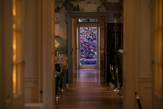 The grand dried flower tree in the conservatory glows at the end of a corridor through the Chinese room during  Yuletide at Winterthur. It's open through Jan. 6.