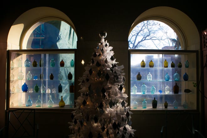 Mack Truax's white tree with diamond ornaments is flanked by windows containing glowing bottles during the annual Yuletide at Winterthur. It runs through Jan. 6.