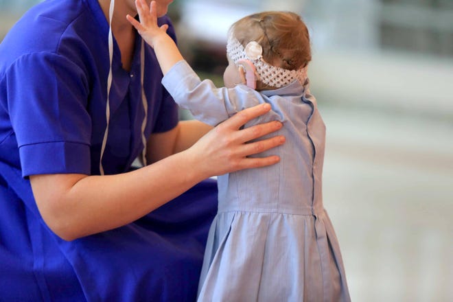 2 year-old Grace reaches for her mother Thelma while taking a walk after an occupational therapy session at Nemour/A.I. duPont Hospital for Children.
