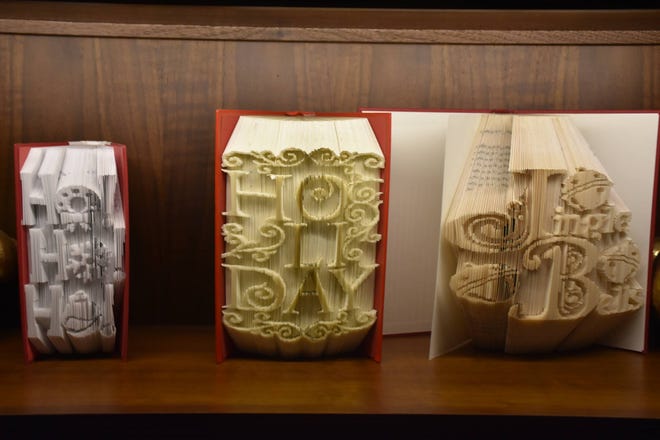 Paper/book artist Dannielle Vincent of Downington created 25 decorative book art sculptures for Longwood Garden's Christmas exhibit, which turns the dining room into a library.