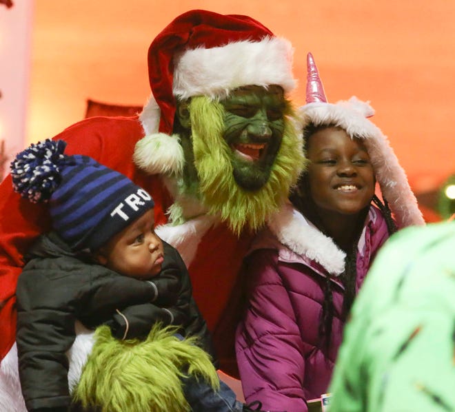 The Grinch, in the form of Matt Place, poses for a photo with Ronald McDonald House guests Joshua (8 months) and Taylor Patton, 8, of Carney's Point, NJ, as the Motorcycle Santa and helpers deliver gifts last week.