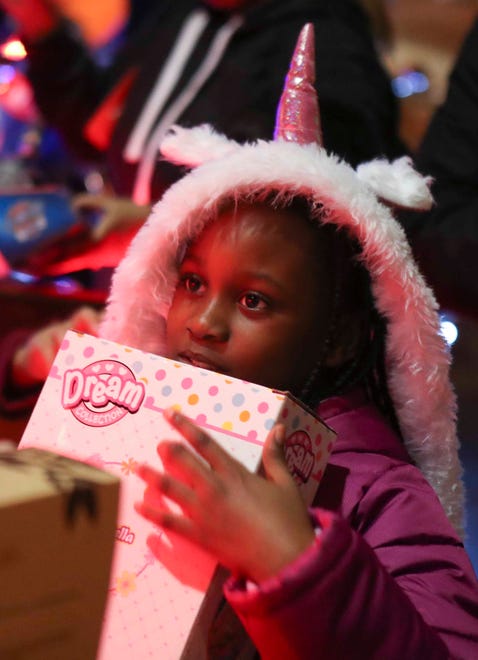 Taylor Patton, 8, of Carney's Point, NJ, holds a toy newly-selected from a delivery by Rocco Malin, the "Motorcycle Santa" and cluster of Santa's helpers at Ronald McDonald House in Rockland last week.
