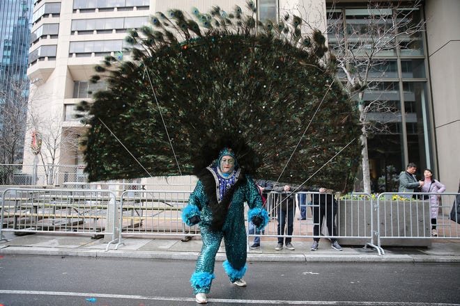 Jennifer Hensell, of Golden Sunrise Fancy Brigade, fights the wind as she waits for the start of the Mummers Parade, Tuesday, Jan. 1, 2019, in Philadelphia. (David Maialetti/The Philadelphia Inquirer via AP)