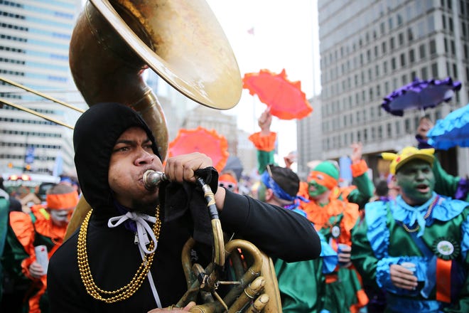 Devoe White plays a sousaphone as members of the Saints Wench Brigade dance in front of City Hall during the Mummers Parade, Tuesday, Jan. 1, 2019, in Philadelphia. (David Maialetti/The Philadelphia Inquirer via AP)