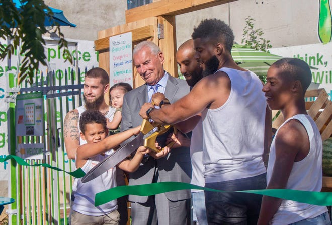 James L.A. Thompson, second from right, participates in the ribbon-cutting for Wilmgitnon Green Box with Wilmington Mayor Michael Purzycki