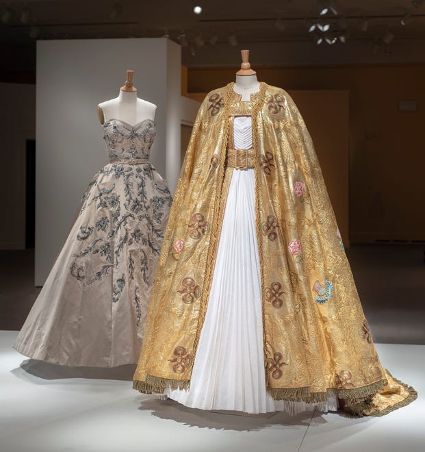 Foreground: Michele Clapton's Imperial Mantle, decorated with symbols of the British empire, is shown over a white pleated dress; background: Clapton's champagne dress was designed to highlight the different in the roles of Princess Margaret and Queen Elizabeth.