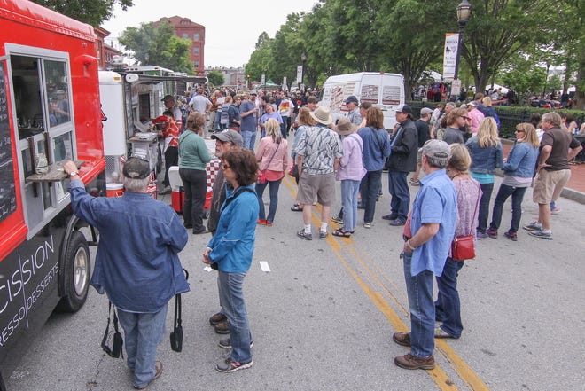 Crowds of people gather at food trucks in between set during Bromberg's Big Noise Music in 2017 at Tubman Garrett Park in Wilmington.