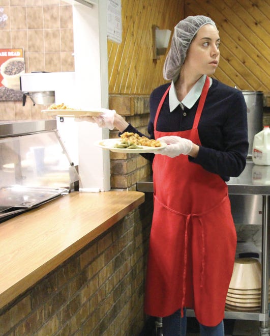 Actress and Wilmington native Aubrey Plaza picks up plates of baked ziti Monday at Wilmington's Emmanuel Dining Room before delivering them to the homeless and poor.