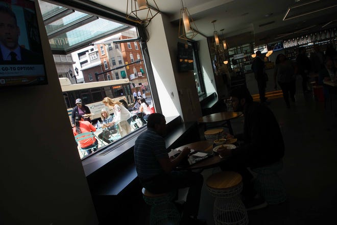 Patrons of the newly opened Wilmington food hall known as DECO  on the first floor of the Hotel duPont enjoy lunch in the outside dining area.
