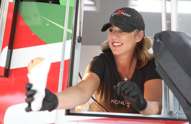 Danielle Sundermeier, co-owner of Kono Pizza, hands a pizza cone to a customer Friday at the Wilmington Riverfront.